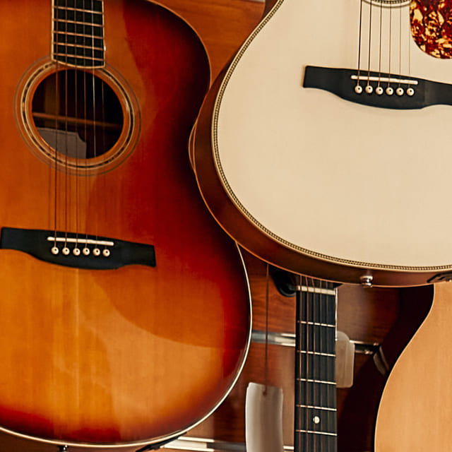 Background image of acoustic guitars in a music store